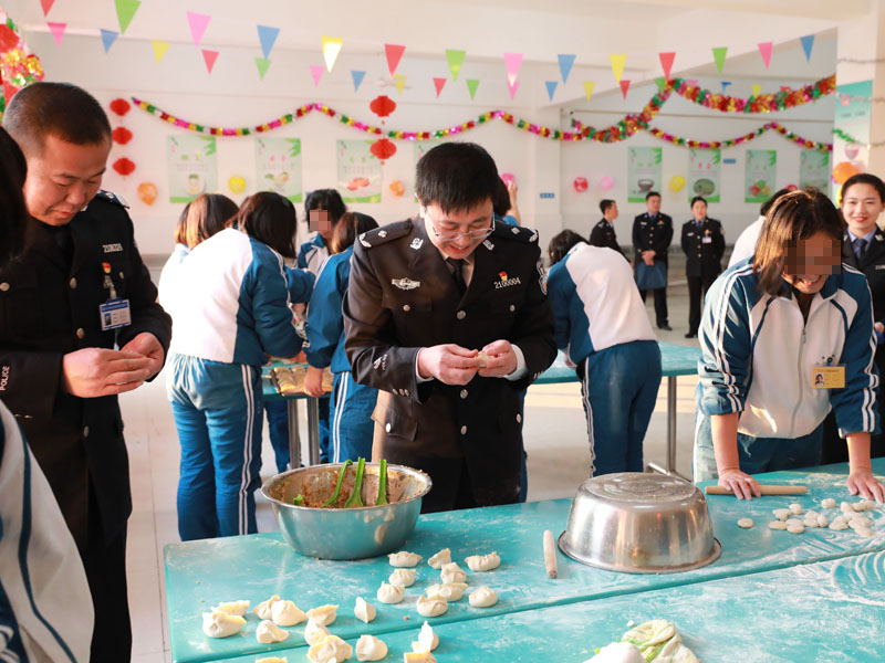 （用）省司法廳戒毒管理局局長段劍平（中）同干警、戒毒學(xué)員一起包餃子。