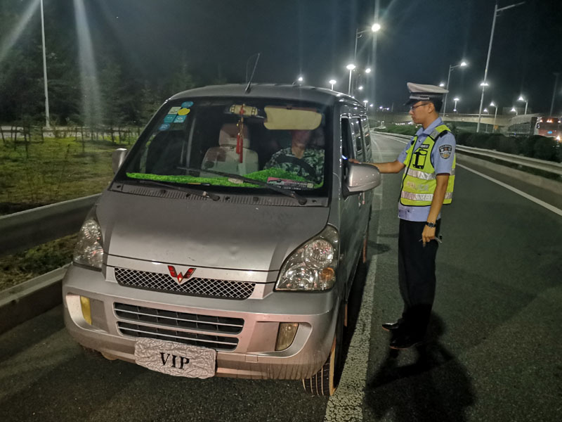 交警正在查處酒駕并故意遮擋號牌的駕駛員孟某