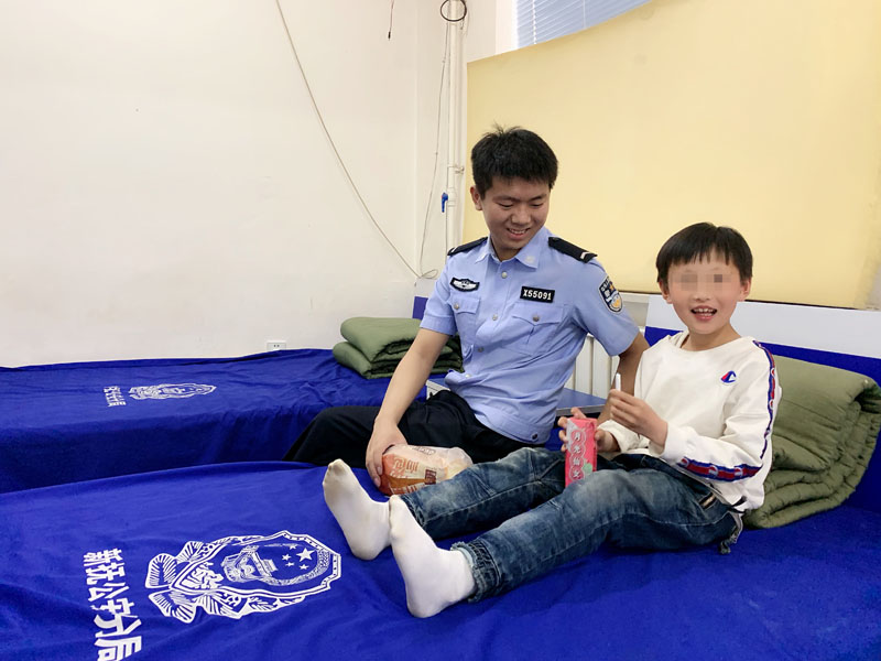 派出所民警正陪著孩子邊吃東西邊看動(dòng)畫片