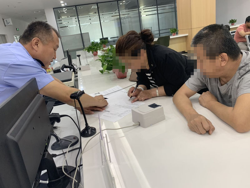 配文1：民警指導(dǎo)辦理護(hù)照的殘障人士手寫簽名