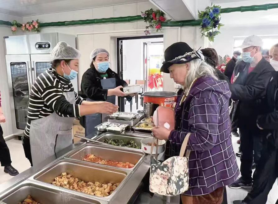 配文1：社區(qū)居民在食堂打飯。