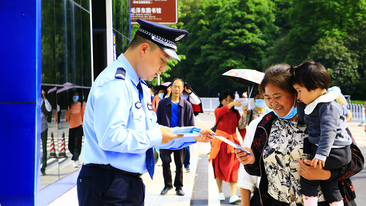 韶山?jīng)_派出所，民警向游客發(fā)放反詐宣傳單