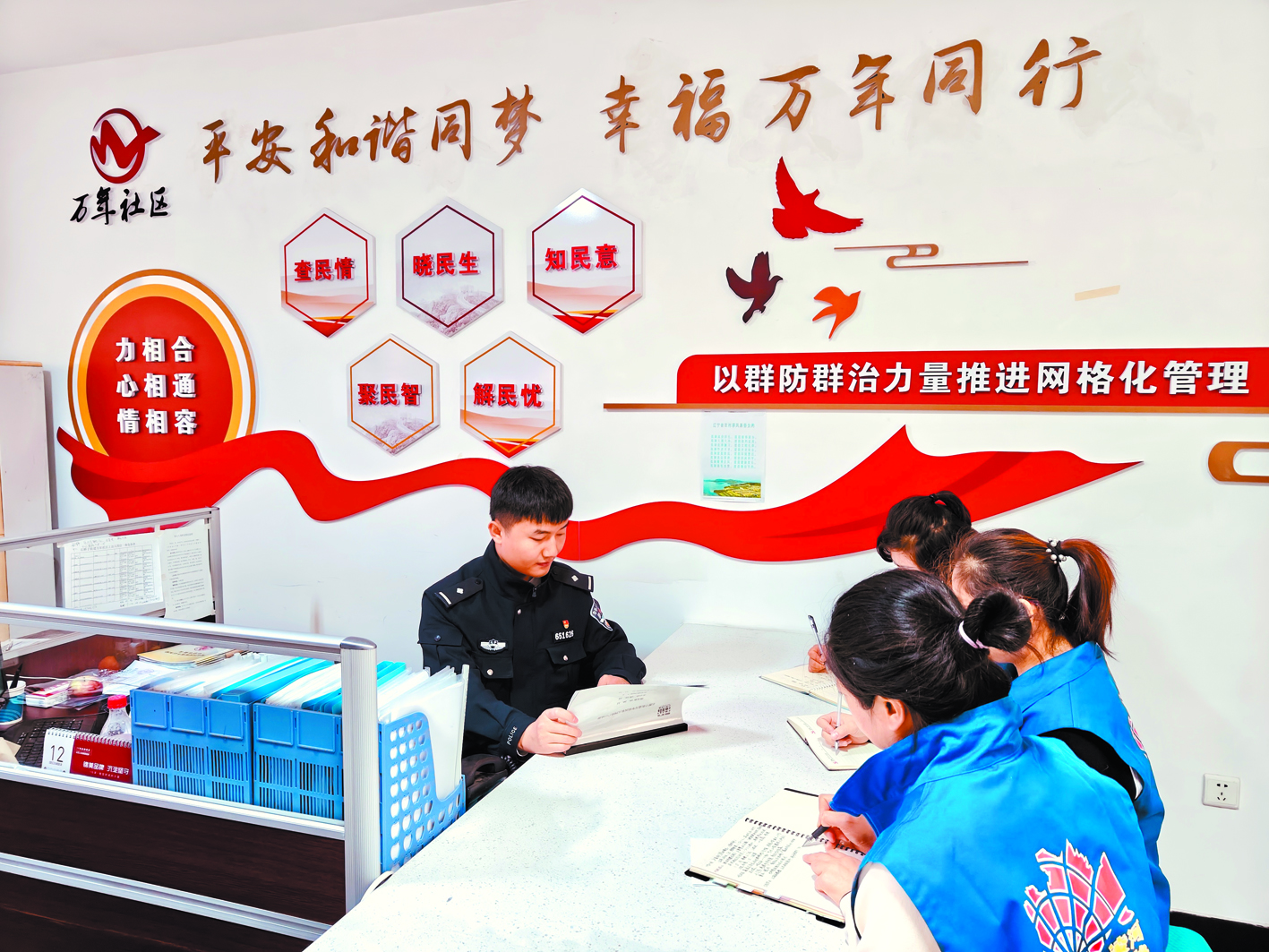 社區(qū)民警與網(wǎng)格員討論物業(yè)糾紛解決方案