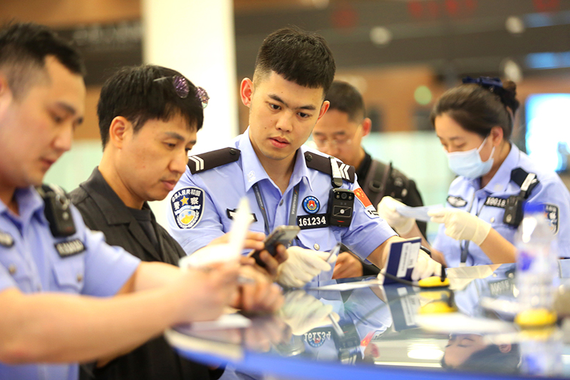 民警協(xié)助外國旅客填寫入境卡片。