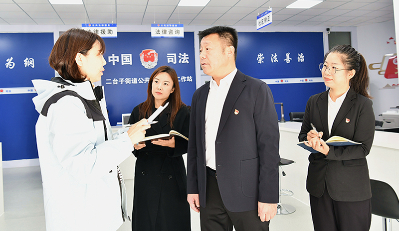 大東區(qū)司法局黨組書記、局長安宏陽（左三）向記者介紹司法所工作情況
