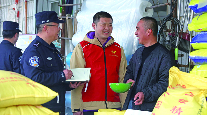 二題圖：在一家農(nóng)藥化肥經(jīng)銷店,民警向店主提示,農(nóng)忙時(shí)電信詐騙多,要注意防范電信詐騙,同時(shí)不要經(jīng)營(yíng)偽劣農(nóng)藥化肥。