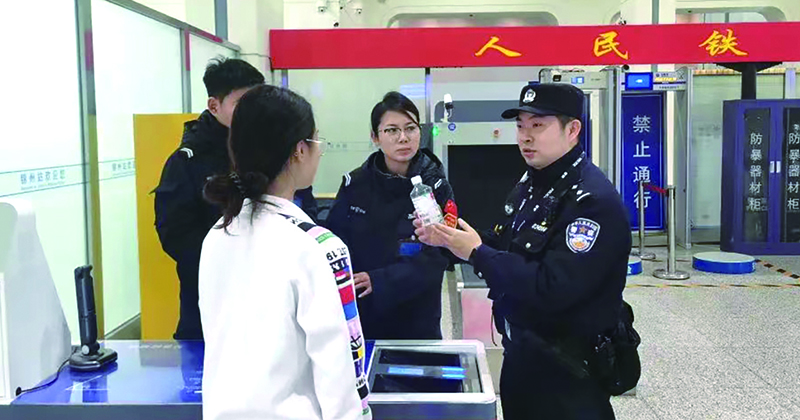 二題圖，童秋華（右）在向旅客講解安檢規(guī)定